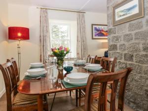 AlfordSteading Cottage - Craigievar Castle的一间带木桌和椅子的用餐室