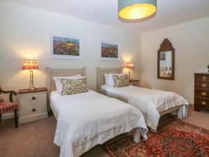 AlfordSteading Cottage - Craigievar Castle的一间卧室配有两张床、一把椅子和镜子