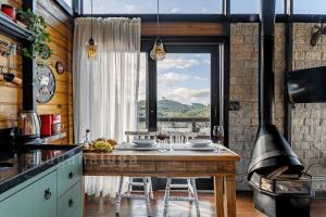 兰舒凯马杜Mountain Chalet Jacuzzi com Vista的厨房配有桌子和大窗户