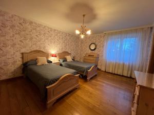 苏安塞斯VILLA OSTRERA的一间卧室配有两张床和吊灯。