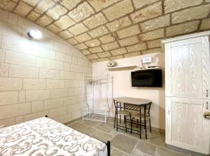 莱切省卡斯特罗L' ATTICO CastroSalento的一间卧室配有一张床、一张桌子和一台电视。