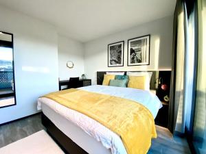 苏黎世GLAD Spot: Zurich - Central - Design - Netflix的一间卧室配有一张带黄色毯子的大床