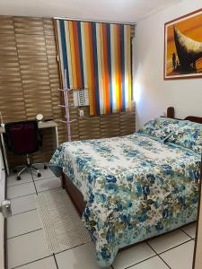 萨尔瓦多EDIFÍCIO METROPOLE ONDINA的一间卧室配有一张带五颜六色棉被的床