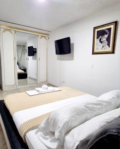布卡拉曼加Hermosa casa en Bucaramanga的白色的客房配有两张床和镜子