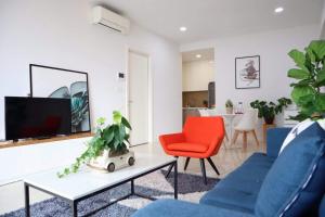胡志明市Delightful Apartment - Masteri Millennium - FREE Infinity Pool的客厅配有2把蓝色椅子和电视