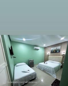 卡塔赫纳HOTEL NUEVO ARIZONA的绿墙客房内的两张床