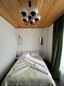 姆茨赫塔Nectar Villa Mukhadtskaro / ვილა ნექტარი მუხადწყარო的一间卧室设有一张带木制天花板的大床