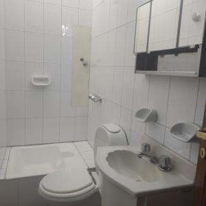 门多萨Tanino Home Suites的白色的浴室设有卫生间和水槽。