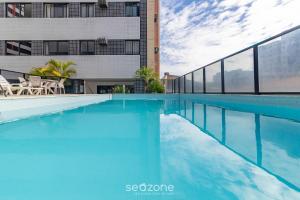 马塞约Apto com piscina bem localizado em Maceió LTS1003的大楼前的蓝色海水游泳池