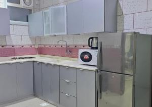 Qarārنور المنازل للوحدات السكنية的厨房配有白色橱柜和冰箱。