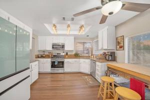 拉斯维加斯Luxury modern home in Las Vegas的厨房铺有木地板,配有白色橱柜。