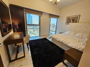 迪拜2 bedrooms flat in Central Park Tower, Dubai, DIFC的一间卧室配有一张床、一张书桌和一个窗户。