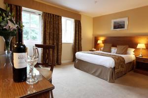 艾恩布里奇贝斯特维斯特山谷酒店的酒店客房,配有一张床和一瓶葡萄酒