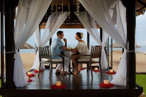 努沙杜瓦巴厘岛康拉德酒店的坐在凉亭桌子上的新娘和新郎