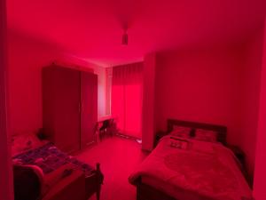 地拉那B&B - Private Rooms的红色的房间,设有两张床和红灯