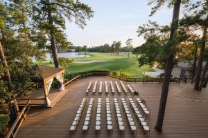 兀兰The Woodlands Resort, Curio Collection by Hilton的甲板上一排带高尔夫球场的白长椅
