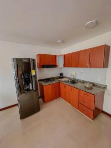 马尼萨莱斯Apartamento Duplex en ubicacion privilegiada的厨房配有木制橱柜和不锈钢冰箱。