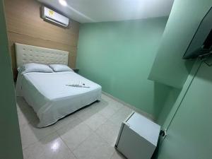 卡塔赫纳HOTEL NUEVO ARIZONA的卧室配有白色的床和电视。