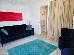 蓬扎Maridea - La Caletta - Luxury Villa的客厅配有黑色沙发和两把椅子