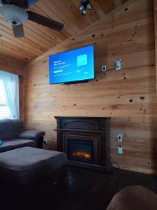 TurtletownPerfectly Imperfect Cabin的客厅设有壁炉和平面电视。