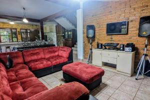 科潘玛雅遗址The Guamacaya House的客厅配有红色家具和砖墙