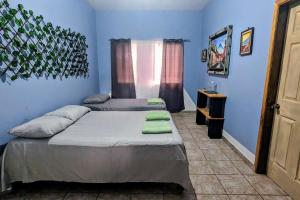 科潘玛雅遗址The Guamacaya House的蓝色墙壁客房的两张床