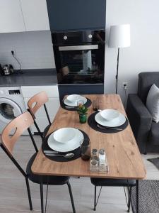 安塔利亚Comfort and Peace in a Luxury Residence!的一张木桌、两把椅子和一张桌子及盘子