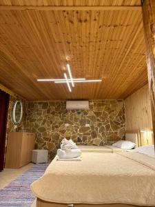吉诺卡斯特"Mani Guest House"的一间卧室设有一张床和石墙
