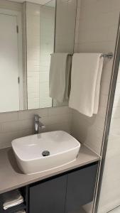 沙迦Al jada / Reef 4的浴室设有白色水槽和镜子