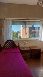 蒙特格兰德Monte Grande Centrico的一间卧室设有紫色的床和大窗户
