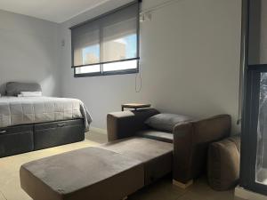 罗萨里奥Premium Apartment Rosario - Joan Miró的一间带沙发、床和窗户的卧室