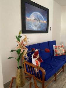 皮斯科Apartamento en Pisco的客厅里一张蓝色的沙发,上面有绘画作品