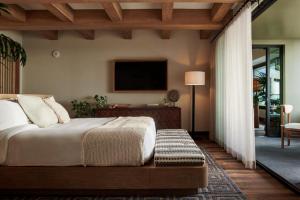 普林斯维尔1 Hotel Hanalei Bay的卧室配有一张床,墙上配有电视。