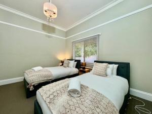 肯图巴Maple Grove的一间卧室配有两张床和吊灯。