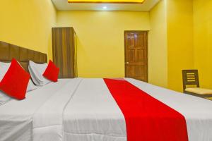 卡兰古特OYO Flagship Peppy Guest House的卧室配有带红色枕头的大型白色床