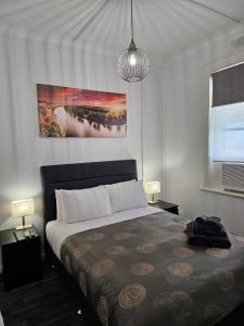 MinlatonMinlaton Hotel的卧室配有一张床,墙上挂有绘画作品