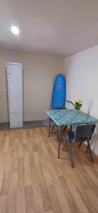 TohautuMaui Homestay的配有桌子和蓝椅的房间