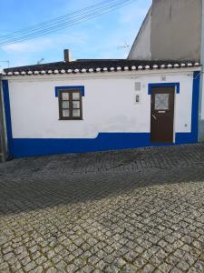 PeroguardaGiacometti Alentejo Peroguarda His last Desire的白色和蓝色的建筑,有门