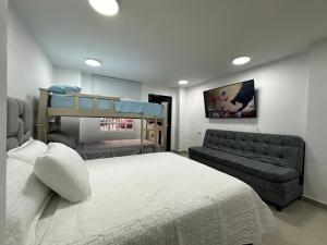 巴耶杜帕尔Con aire acondicionado Apartamento, Las flores的一间卧室配有双层床和沙发