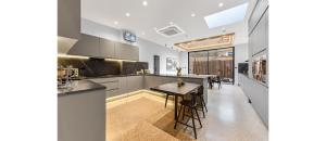 伦敦Luxury Abode: 5-Bed Haven Ideal for Big Groups!的一间带桌子的厨房和一间餐厅