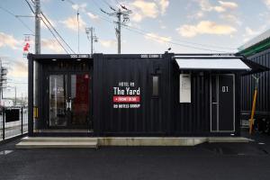 松阪市HOTEL R9 The Yard 松阪的前面有标志的黑色建筑