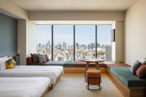 东京OMO5 東京五反田 by 星野集团(OMO5 Tokyo Gotanda by Hoshino Resorts)的酒店客房设有两张床和大窗户。
