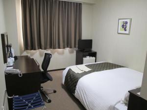 大川大川河畔酒店 的酒店客房配有一张床、一张书桌和一台电脑