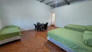 EscuintlaVilla Santos的一间设有两张床和一张桌子及椅子的房间