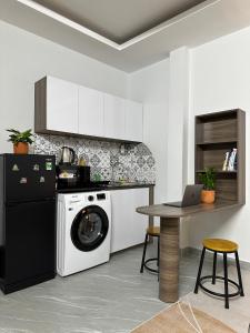 胡志明市Calmette Home的厨房配有洗衣机和带笔记本电脑的桌子。