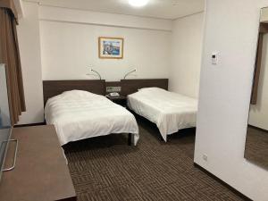 津山市Hotel Alpha-One Tsuyama的酒店客房,配有两张带白色床单的床