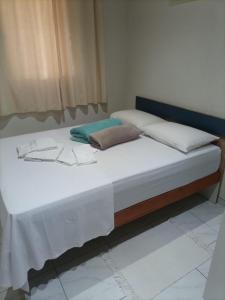 圣安东尼奥-杜皮尼亚尔Cantinho Aconchego的一张配有白色床单和枕头的大床