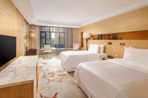 上海上海威斯汀大饭店的酒店客房配有两张床和一张书桌