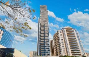 悉尼Parramatta 2B2B High Floor apt next to Train and shopping的一座高高的建筑,位于一些高大的建筑前