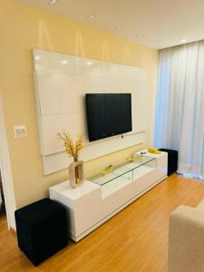 维拉维尔哈Brisa Mar的客厅设有壁挂式平面电视。